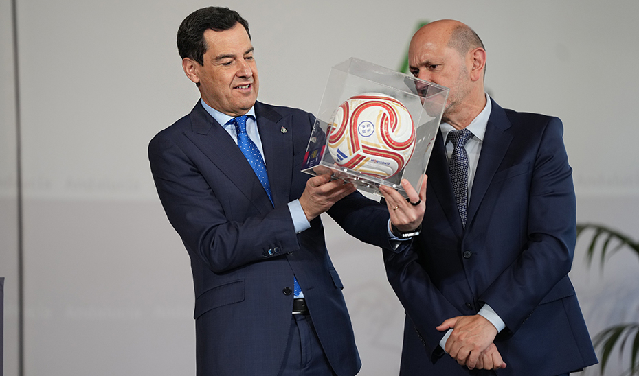 Juanma Moreno recibe de manos del Javier Louz&aacute;n el bal&oacute;n de la final de la Copa del Rey 2026, que se disputa en el Estadio de la Cartuja de Sevilla.