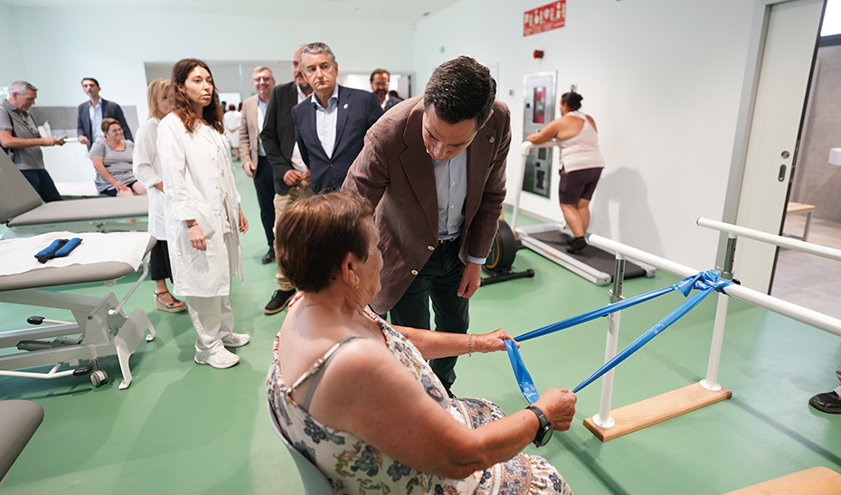 El presidente Juanma Moreno conversa con los pacientes del espacio de rehabilitación fisioterapéutico.